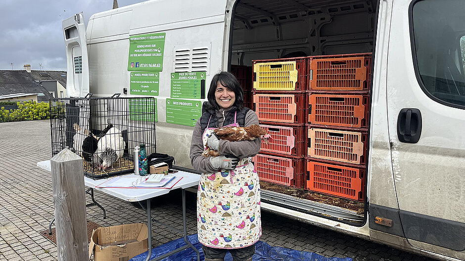 photo d'une poule dans les bras de cécile, vendeuse pour Poule pour tous